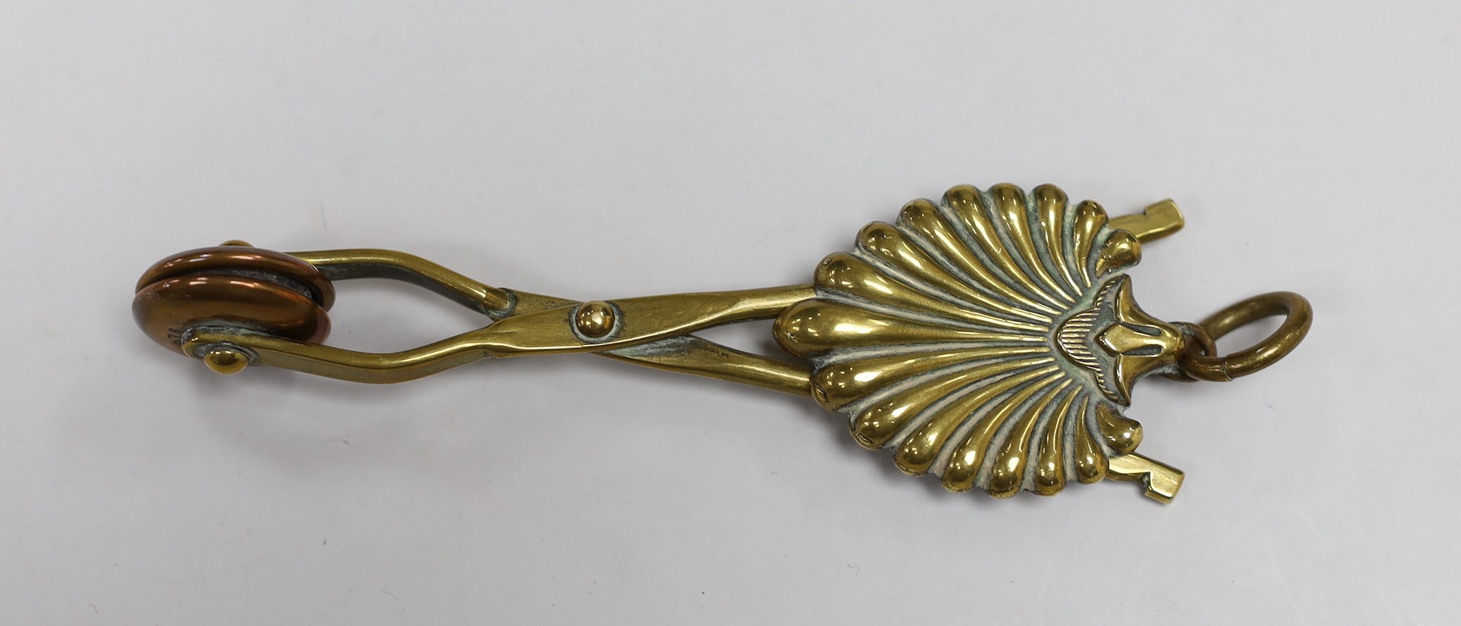 A brass skirt hem lifter. 14cm long